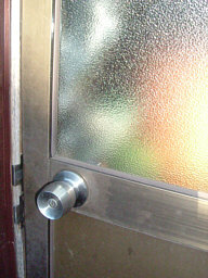 よく見かける一戸建て住宅の勝手口の扉、ドアノブ付近のガラスを割ると鍵がすぐに開けられます。